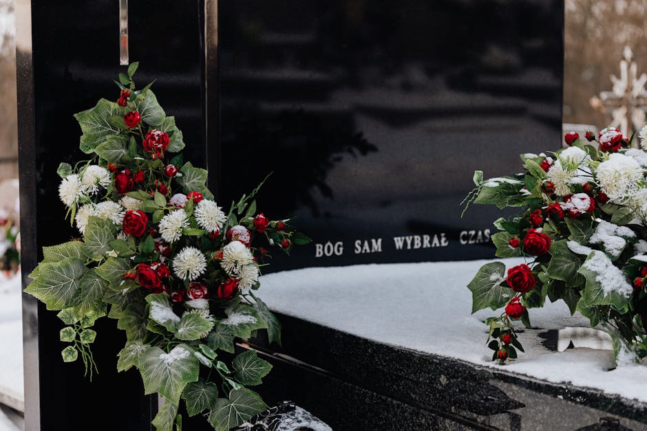 A Funeral Flowers floral arrangement featuring two large white vases filled with cream and white roses, hydrangeas, and peonies, accented by green foliage. The vases are positioned on either side of a